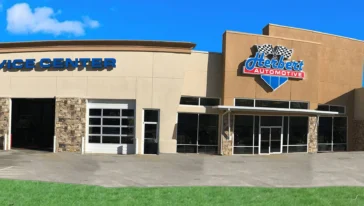 Exterior view of an automotive service center with multiple garage bays, a sign reading "Herbert Automotive" on the building, and clear primary navigation for customers arriving onsite.